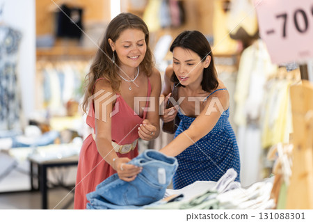 Two female friends choose jeans in the store 131088301