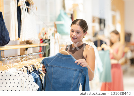 Young woman choosing jacket in clothing store 131088443