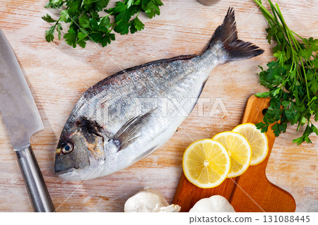 Gilthead bream with vegetables, lemon and spices 131088445