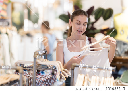 Girl customer chooses singlet blouse in branded store 131088545