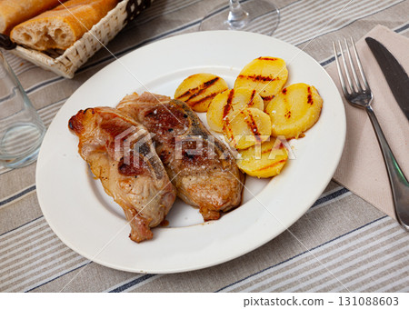 Baked pork bone-in sirloin chops with grilled potatoes Baked pork bone-in sirloin chops with grilled potatoes 131088603