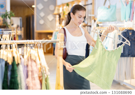 Girl customer chooses singlet blouse in branded store 131088690