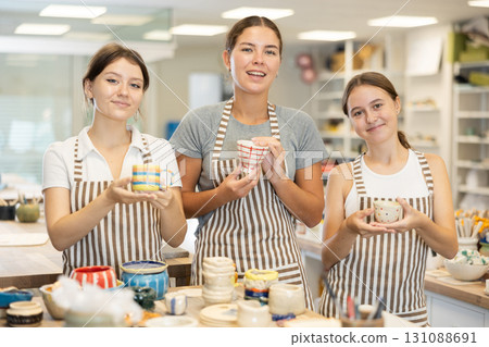 Female teacher and students with handmade ceramic cups Female teacher and students with handmade ceramic cups 131088691