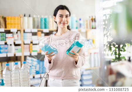 Young woman chooses mouthwash at pharmacy Young woman chooses mouthwash at pharmacy 131088725