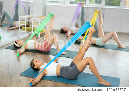 Group of young women doing pilates with band 131088727