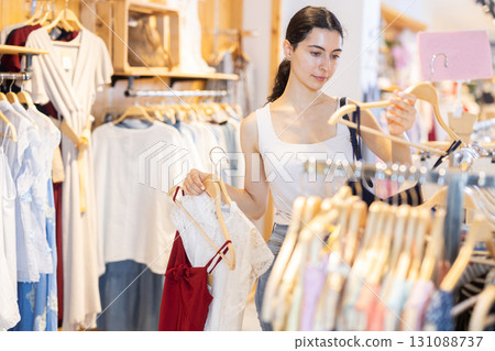 Woman choosing clothes in the department with discounts Woman choosing clothes in the department with discounts 131088737