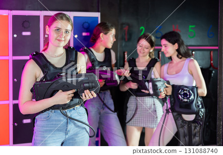 Break in game - portrait of a happy girl with gun for playing laser tag Break in game - portrait of a happy girl with gun for playing laser tag 131088740