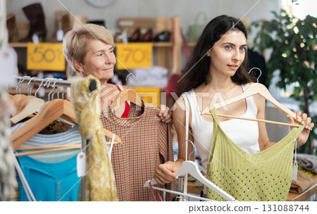 Two women choosing clothes on sale in a store Two women choosing clothes on sale in a store 131088744