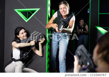 Girls play laser tag, jokingly fight with light weapons Girls play laser tag, jokingly fight with light weapons 131088767