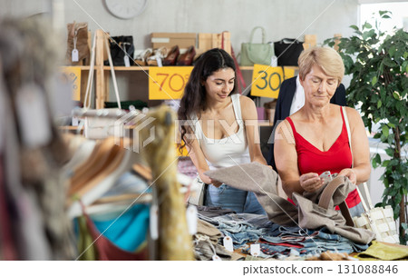 Woman customer with senior mother making choice and elect pants in store Woman customer with senior mother making choice and elect pants in store 131088846