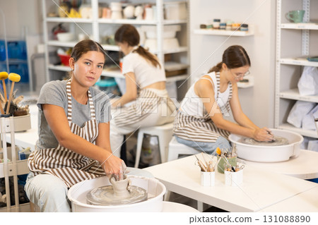Woman teacher and students make products on potter's wheel 131088890