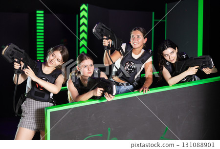 Girls play laser tag, jokingly fight with light weapons Girls play laser tag, jokingly fight with light weapons 131088901