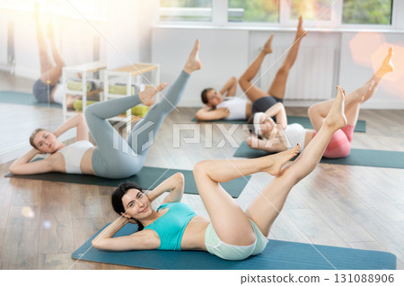 Young girls doing press exercise in pilates studio 131088906