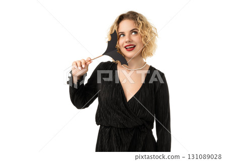 Playful woman with bat mask at Halloween, isolated on white, PNG 131089028