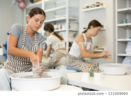 Woman teacher and students make products on potter's wheel 131089060