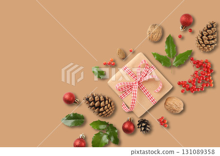 A lovely gift sits among festive pinecones and berries A lovely gift sits among festive pinecones and berries 131089358