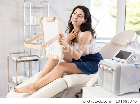 woman gazes at herself in mirror woman gazes at herself in mirror 131089370