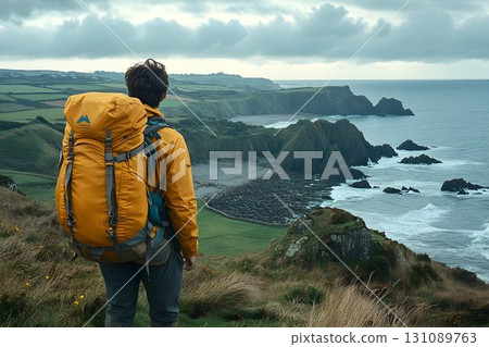 Coastal Hike: Backpacker Gazing at Dramatic Cliffs and Ocean Coastal Hike: Backpacker Gazing at Dramatic Cliffs and Ocean 131089763