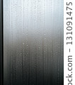 Detailed Close-up of Raindrops Sliding Down a Misty Glass Surface 131091475