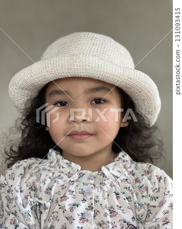 Portrait of Asian little girl with white hat on gray background. Portrait of Asian little girl with white hat on gray background. 131093415