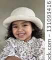 Portrait of a little girl with white hat smiling at the camera Portrait of a little girl with white hat smiling at the camera 131093416
