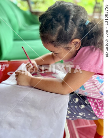 Little girl drawing with colored pencils in the living room at home 131093759
