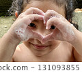 Close up of little girl showing heart shape with her hands and face Close up of little girl showing heart shape with her hands and face 131093855