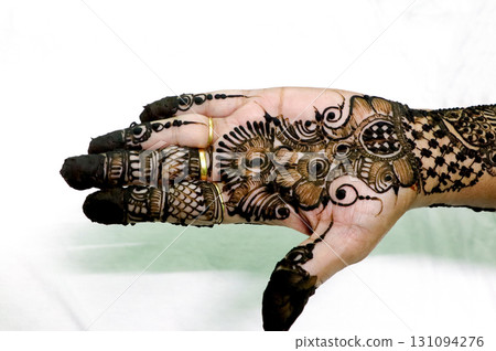 Picture of human hand being decorated with henna tattoo,Decorated Mehendi cone in Indian wedding ceremony Picture of human hand being decorated with henna tattoo,Decorated Mehendi cone in Indian wedding ceremony 131094276