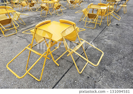 Yellow Folding Chairs and Tables on Pavement. Yellow Folding Chairs and Tables on Pavement. 131094581
