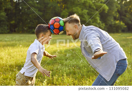 Happy father and son are having fun and playing with ball in green park in summer Happy father and son are having fun and playing with ball in green park in summer 131095082