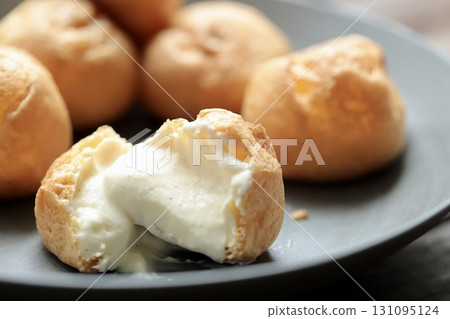 泡芙橫切面,外皮柔軟,奶油豐富 泡芙橫切面,外皮柔軟,奶油豐富 131095124
