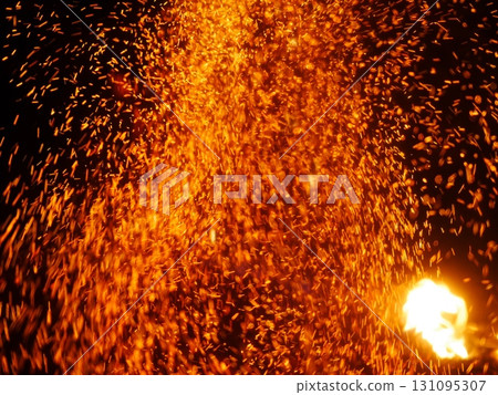 The image is of a fire with a lot of orange sparks flying out of it 131095307