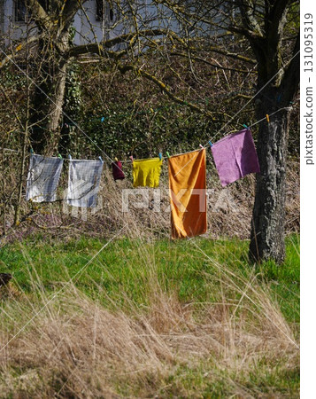 Line of clothes hanging on a clothesline in a field 131095319