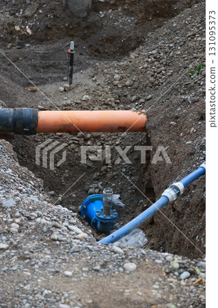 Blue pipe is in the ground next to a yellow pipe 131095373