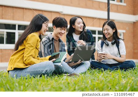 Asian Students are studying the campus park. Young people are spending time together. Reading book, working with laptop and tablet sitting on stairs Asian Students are studying the campus park. Young people are spending time together. Reading book, working with laptop and tablet sitting on stairs 131095467