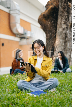 Asian Students are studying the campus park. Young people are spending time together. Reading book, working with laptop and tablet 131095593