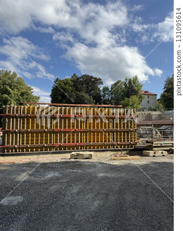 An Active Construction Site Featuring Stacked Formwork Surrounded by a Clear Blue Sky 131095614