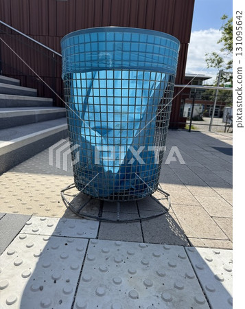A blue wire trash bin along the pathway boosts both aesthetics and functionality 131095642