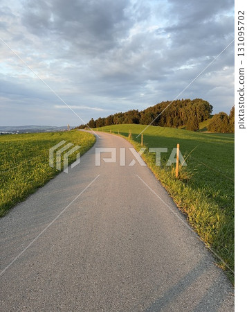 A Peaceful, Curved Pathway Surrounded by Lush and Beautiful Green Fields Awaits You A Peaceful, Curved Pathway Surrounded by Lush and Beautiful Green Fields Awaits You 131095702