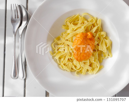 Plate of pasta with a sauce on top 131095707