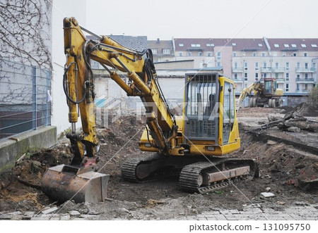 Yellow construction machine is digging in the dirt Yellow construction machine is digging in the dirt 131095750