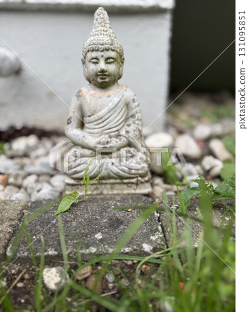 A Serene Buddha Figurine Placed within a Beautifully Tranquil Garden Landscape Setting 131095851