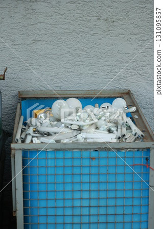 Blue container filled with white light bulbs 131095857