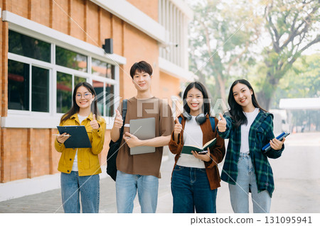 Young people college students is reading a book while relaxing sitting on grass in a campus park 131095941