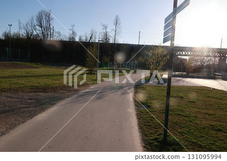 A path in a park with a sign on the right 131095994