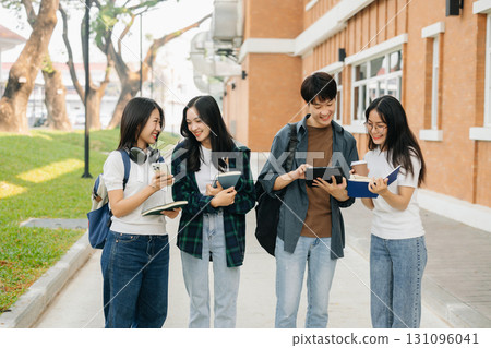Young Asian college students and a female student group work at the campus park 131096041
