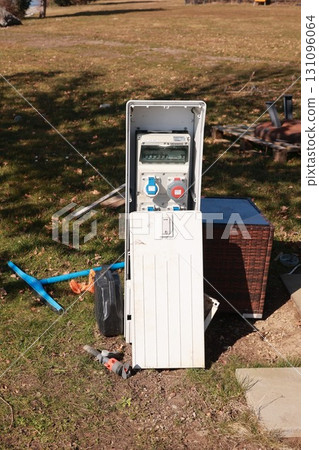 A white box with a black cover is sitting on the grass 131096064