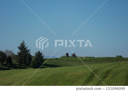 A field with a tractor and a man in a tractor A field with a tractor and a man in a tractor 131096099