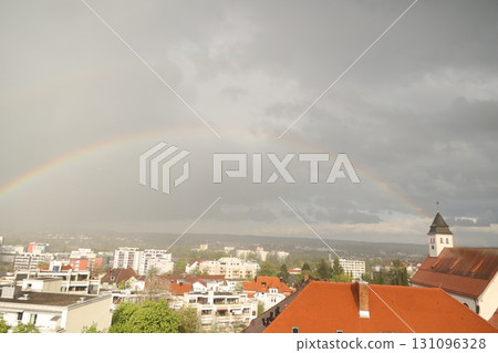 A rainbow is seen over a city with a church in the background A rainbow is seen over a city with a church in the background 131096328
