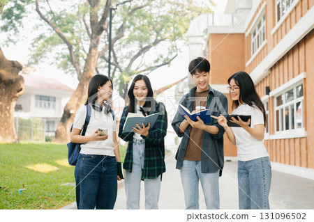 Young Asian college students and a female student group work at the campus park 131096502